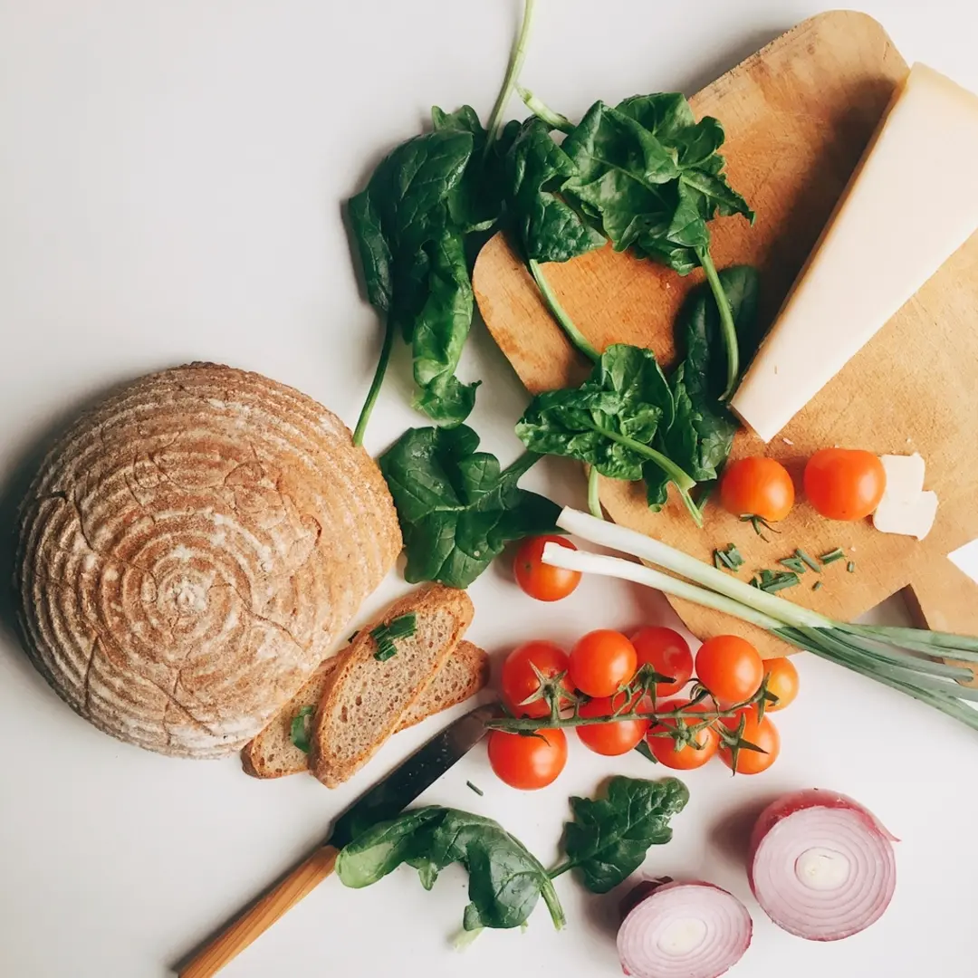 Fresh whole foods: bread, spinach, cheese and tomatoes on a table